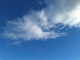 Fototapeta premium Blurred blue sky bokeh background with soft white and gray clouds, dreamy atmospheric texture for calm weather designs