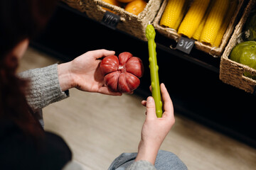 Choosing decorative candles shaped like vegetables in gift store.