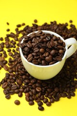 Fototapeta premium Aromatic coffee beans and cup on yellow background