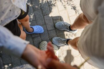 Family walk outdoors. Parents and children take photos of their feet, hands, and sidewalk during...