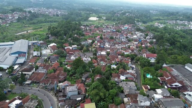 Smooth Aerial Drone Footage of Dense Residential Neighborhood with Curved Road and Green Landscape
