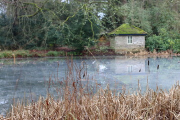 Obraz premium View across a lake in winter to a boathouse
