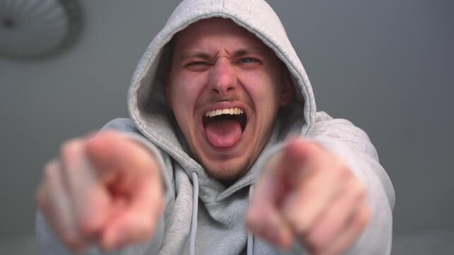 An adult man mocks and humiliates someone.
Mocking and bullying.
A man points at a person and laughs at them.