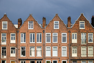 Fototapeta premium Row of traditional European brick houses with gabled roofs in Amsterdam, Netherlands