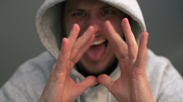A cunning man in a hood rubs his hands.
A vindictive man rubs his palms and waits for revenge.
Revenge and a cunning plan