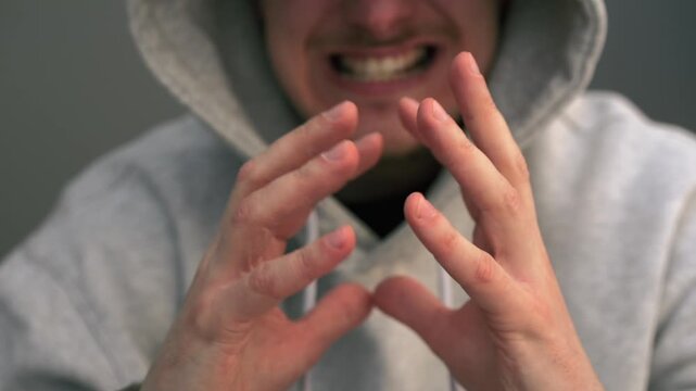 A man with a cunning plan rubs his palms.
A gesture of a vengeful man.
The emergence of a plan and a cunning plot.