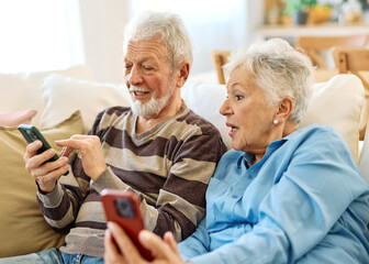 Portrait of an elderly senior couple using a mobile phone at home