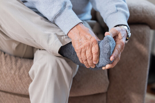 Elderly man holds his foot suffer from foot pain