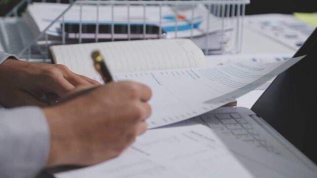 Asian male financial officer or accountant checking investment results Financial budget analysis Planning to summarize results and report to the meeting Audit concept and investment results.