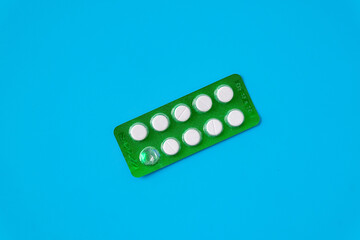 Medical drugs and pills in package on color background.