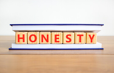 Honesty word symbol. Concept word Honesty on beautiful wooden blocks in book. Beautiful wooden table white background. Business honesty concept. Copy space.