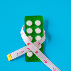 A pills and a measuring tape suggest a journey towards health.