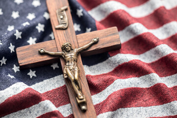 Wooden crucifix on wavy American flag