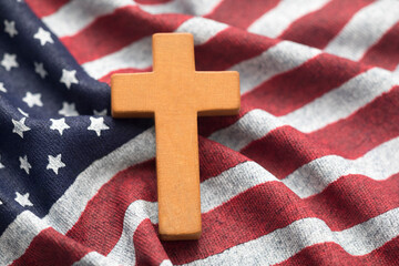 Wooden cross on wavy American flag