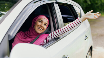 Rear view of little boy leaning out of car window and trying to catch wind with outstretched hand, small male child enjoying summer weather and automobile ride, on the move shot, closeup