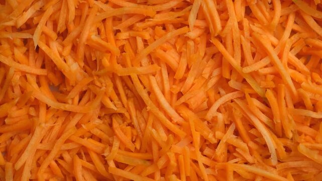 Close up of bright orange carrot julienne spinning slowly.
