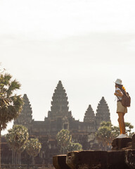 Young Woman Traveler Looking at Angkor Wat Temple from Ruins