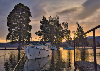 Fototapeta premium Colourful sunset reflecting on boats at Lake Te Anau Marina