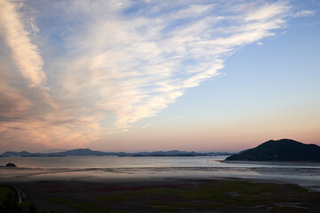 Fototapeta premium Dramatic Cirrus Clouds Over Coastal Tidal Mudflats at Sunset of Suncheon Bay Wet Reserves, South Korea.