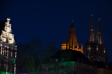 Fototapeta premium Nächtliche Ansicht von Köln mit den angestrahlten Türmen von Rathaus und Dom 