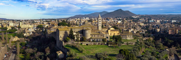Obraz premium Panoramic Aerial View of Viterbo Skyline: Medieval Papal Palace and Historic Center against Monte Cimino Backdrop, Lazio Italy