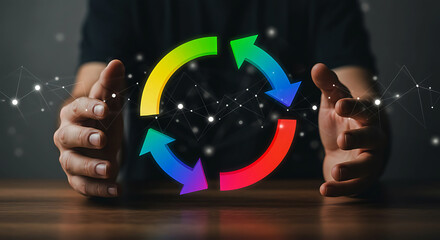 Hands cradling a colorful circular arrow cycle with blue green yellow and red segments arrows loop
