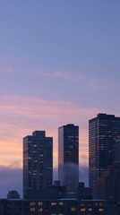 Obraz premium Modern High Rise Towers Emerging Through Mist at Dawn in Urban Landscape
