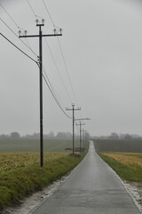 Ligne &eacute;lectrique le long d'une route de campagne par temps de pluie &agrave; Frasnes-Lez-Gosselies (Charleroi)