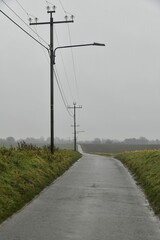 Ligne &eacute;lectrique le long d'une route de campagne par temps de pluie &agrave; Frasnes-Lez-Gosselies (Charleroi)