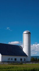 Vertical Shot of Farmhouse and Silo Framed Against Clear Blue Sky