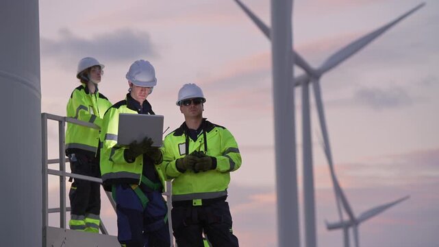 Engineers working on site in wind turbine farm at sunset, Wind turbines generate clean energy source, Eco technology for electric, industry environment, sustainable technology wind power maintenance.