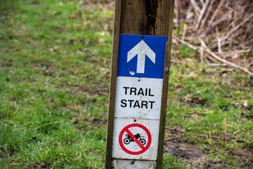 Start of mountain bike trail sign attached to a wooden post. 