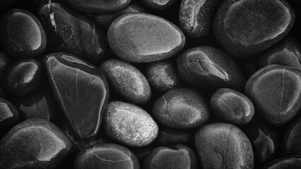 Fototapeta premium Wet Pebbles stones on seashore as texture background for design web banner template page. SPA concept background