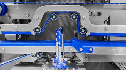 A close-up of a conveyor for packaging pharmaceuticals and tablets. The conveyor is modern and clean. Pharmaceutical concept.