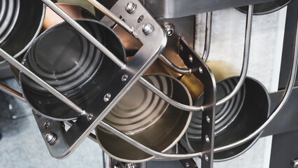 A conveyor belt for packing food products into metal cans, the cans are moved for further packaging