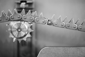 A chain with a round gear. The chain is made of metal. Industrial concept, teamwork concept.