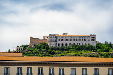 Fototapeta premium View of Castel Sant Elmo from below in Naples, Italy, showing the fortress towering above the city with its massive stone walls and historic hilltop presence.