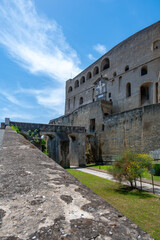 Fototapeta premium Entrance walls of Castel Sant Elmo in Naples, Italy, showing massive stone fortifications and historic military architecture under bright Mediterranean daylight.