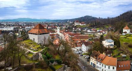 Fototapeta premium Aerial Panorama of Kamnik Central Street and Mali Grad Castle: Medieval Architecture, Church Spires and Alpine Town Perspective, Slovenia