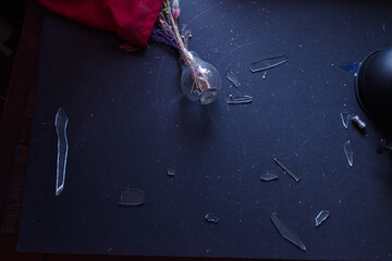 Broken glass after the attack. Glass fragments on the table. Upturned flower pot on the table.