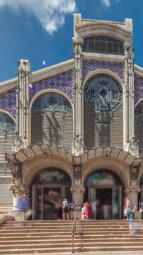 Valencia Central Market timelapse hyperlapse. Historic public market with stunning architecture, stained glass, dome and tile details. Located in Market Square near Santos Juanes Church. Spain