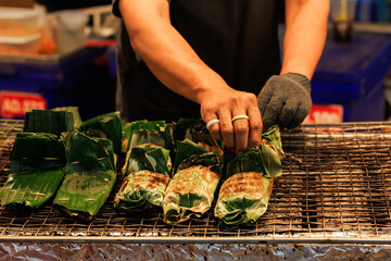 Motion blur of a busy chef at work. The energetic atmosphere of Thai night