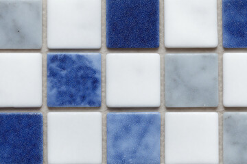 Fototapeta premium Close-up of a mosaic tile pattern with blue, white, and gray squares