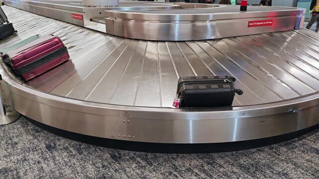 Baggage claim carousel conveyor belt with luggage bags at the airport.