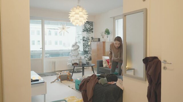 A warm indoor scene featuring festive decor and a relaxed atmosphere. The room has a mix of holiday spirit with a cozy touch, showcasing personal items and a hint of disarray, creating an inviting hom