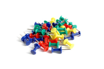 There is a pile of multi-colored pushpins on a white background.