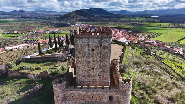 High altitude drone approach to Nogales medieval castle revealing the village behind
