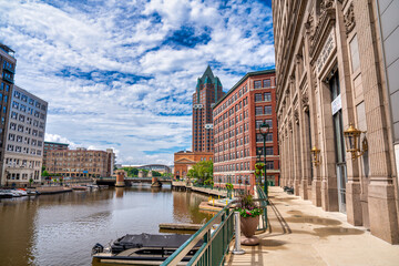 Milwaukee, WI - July 29, 2024: Scenic view of Milwaukee buildings along the river reflecting in the calm waters