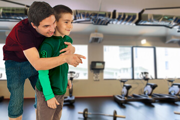 A man is helping a young boy in a gym