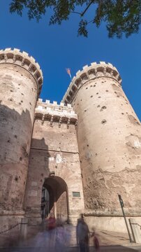 Towers of Quart timelapse hyperlapse in Valencia, Spain. Historical medieval gate, part of the ancient city walls. Popular landmark with a rich cultural heritage. Blue sky and street traffic scene.